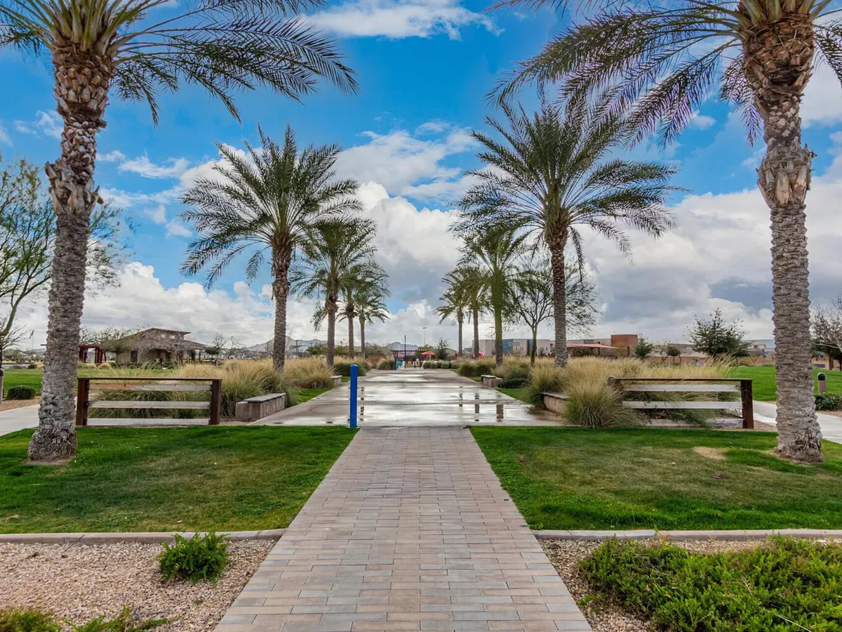 A tranquil park-like setting with palm trees, a winding pathway, benches, and a water feature. The scene evokes peaceful outdoor exploration and is suited to activities like taking restorative walks or enjoying quiet time in nature.