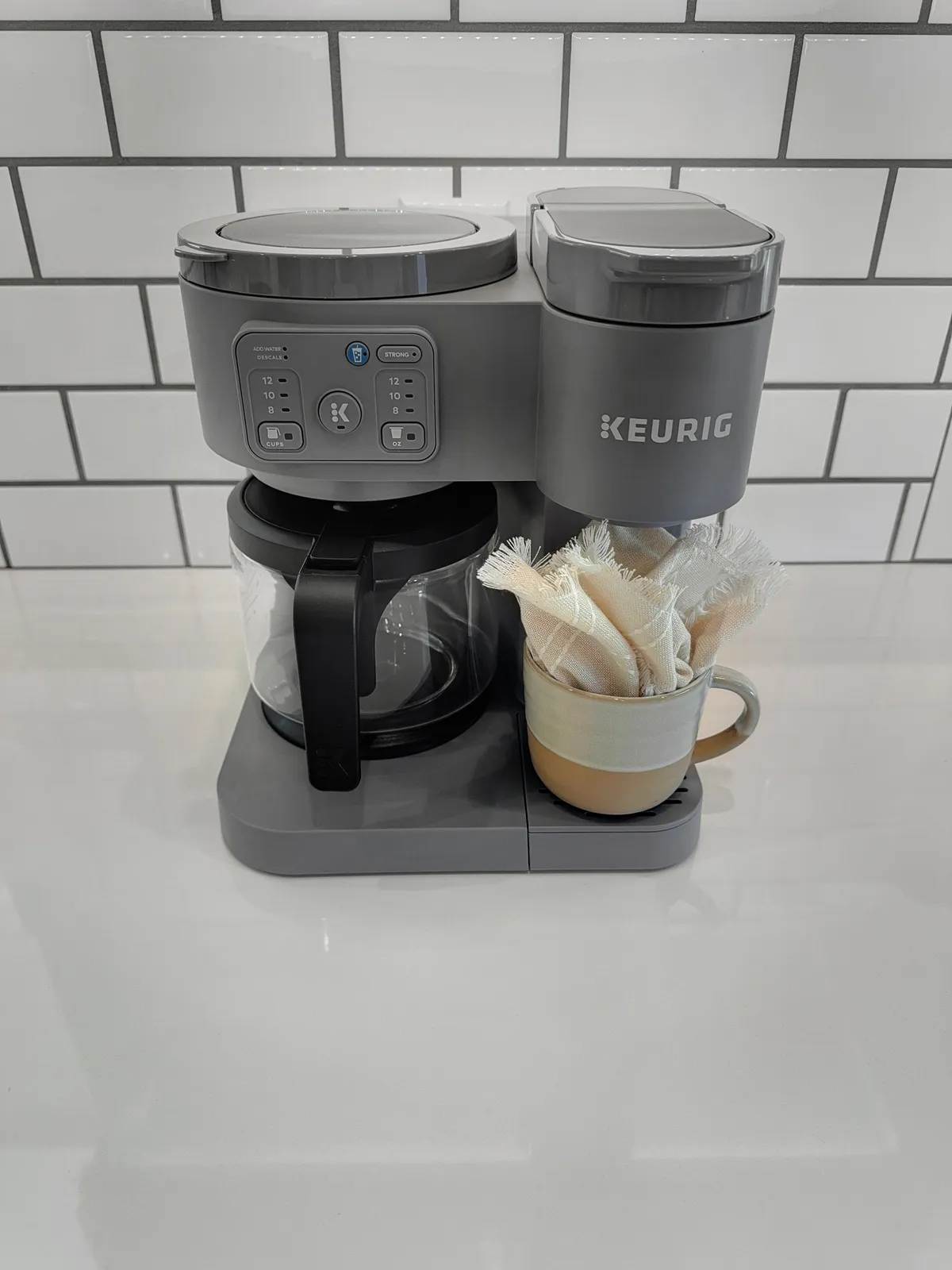A dedicated coffee station with a Keurig coffee maker, fresh cup, and coffee filters, set on a tidy countertop. The scene evokes cozy morning rituals and provides a glimpse of thoughtful amenities for guests.